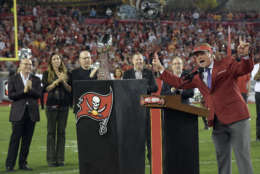 Former Tampa Bay Buccaneers Jon Gruden, far right, raises his arms to the fans as he is inducted into the teams Ring of Honor during halftime at an NFL football game between the Tampa Bay Buccaneers and the Atlanta Falcons, Monday, Dec. 18, 2017, in Tampa, Fla. (AP Photo/Phelan M. Ebenhack)