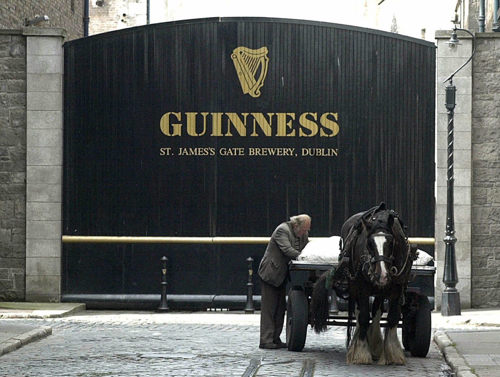 A man and his dray horse stop to adjust their load outside the gates of the Guinness Brewing Company in Dublin, Ireland Sept. 14, 2000.  The Hopstore at the sprawling brewery complex is  a popular stop for visitors to Dublin. (AP Photo/John Cogill)