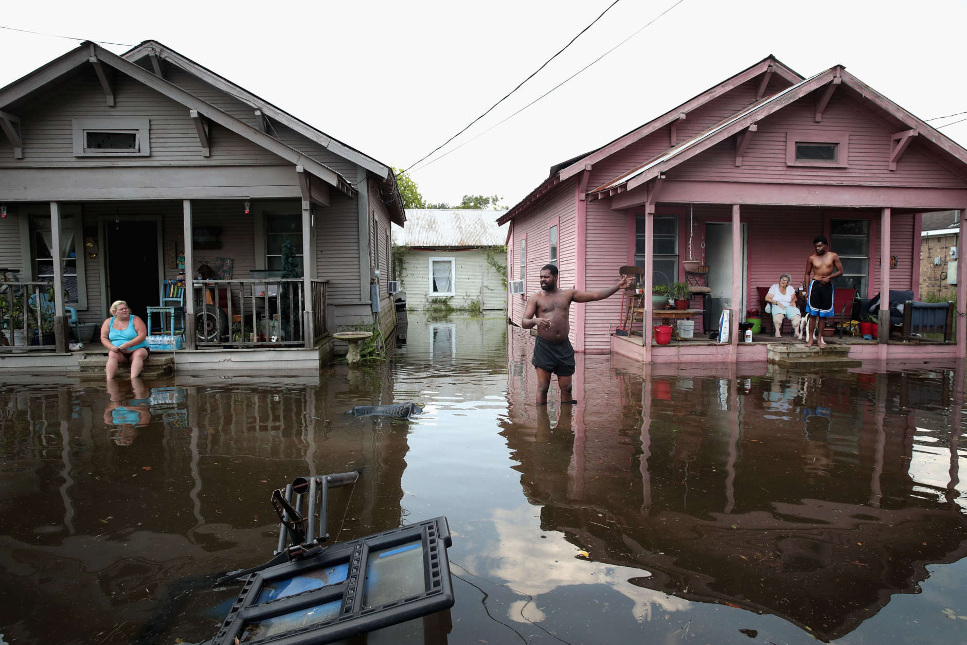 ORANGE, TX - SEPTEMBER 02:  Residents hang out in front of their homes which are surrounded by floodwater after torrential rains pounded Southeast Texas following Hurricane and Tropical Storm Harvey causing widespread flooding on September 2, 2017 in Orange, Texas. Harvey, which made landfall north of Corpus Christi August 25, has dumped nearly 50 inches of rain in and around areas Houston.  (Photo by Scott Olson/Getty Images)