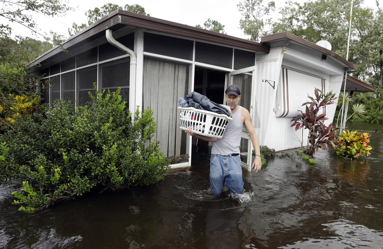 Grady Howell, of Plant City, Fla., helps a friend salvage items from a flooded mobile home Monday, Sept. 11, 2017, after Hurricane Irma moved through the area in Lakeland, Fla. (AP Photo/Chris O'Meara)