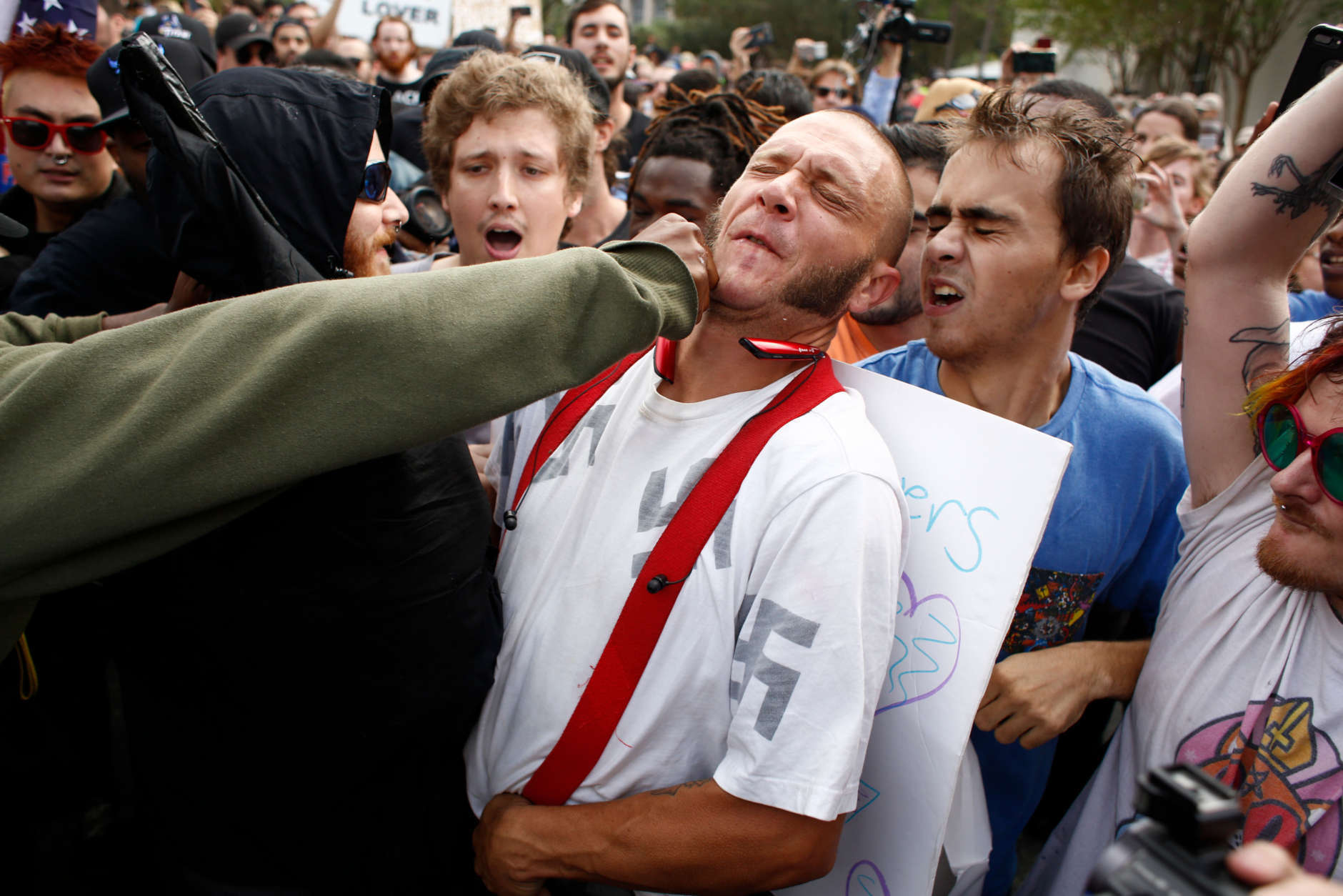 GAINESVILLE, FL - OCTOBER 19:  A man wearing a shirt with swastikas on it is punched by an unidentified member of the crowd near the site of a planned speech by white nationalist Richard Spencer, who popularized the term 'alt-right', at the University of Florida campus on October 19, 2017 in Gainesville, Florida. A state of emergency was declared on Monday by Florida Gov. Rick Scott to allow for increased law enforcement due to fears of violence. (Photo by Brian Blanco/Getty Images)