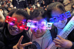 Residents wear 2018 glasses, during New Year's Eve to celebrate the upcoming year 2018 in Hong Kong, Sunday, Dec. 31, 2017. (AP Photo/Kin Cheung)