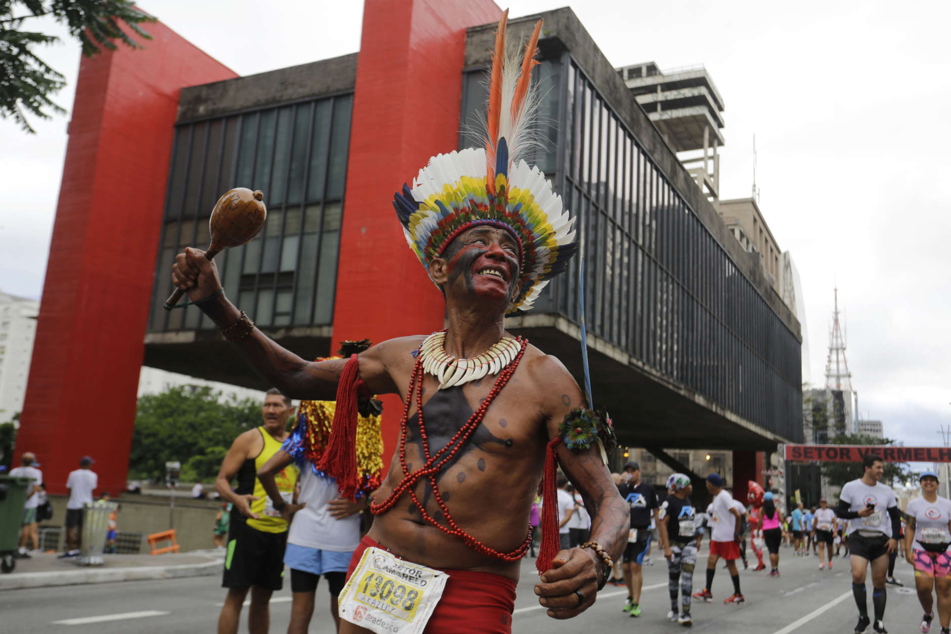A runner in indigenous attire poses for a photo prior to the Sao Silvestre race in Sao Paulo, Brazil, early Sunday, Dec. 31, 2017. The 15-kilometer race is held annually on New Year's Eve. (AP Photo/Nelson Antoine)