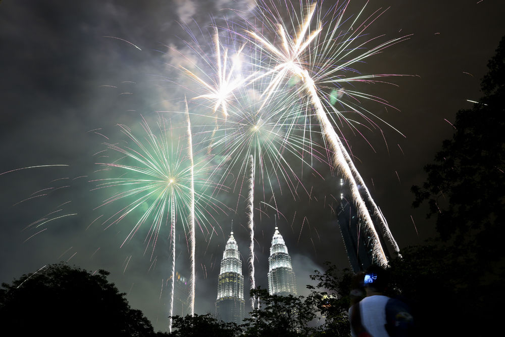 Fireworks explode  in front of Malaysia's landmark building, the Petronas Twin Towers, during the New Year's celebration in Kuala Lumpur, Malaysia, Monday, Jan. 1, 2018. (AP Photo/Sadiq Asyraf)