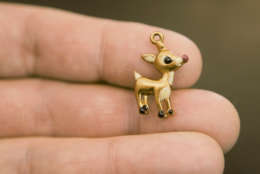 In this Dec. 17, 2009 photo, Jeff Weidenhamer, professor of chemistry at Ashland University, holds a "Rudolph the Red-Nosed Reindeer", charm in Ashland, Ohio. Barred from using lead in children's jewelry because of its toxicity, some Chinese manufacturers have been substituting the more dangerous heavy metal cadmium in sparkling charm bracelets and shiny pendants being sold throughout the United States, an Associated Press investigation shows.  (AP Photo/Tony Dejak)