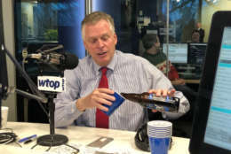 Virginia Gov. Terry McAuliffe pours a beer in the Glass Enclosed Nerve Center on Friday, Dec. 22, 2017, to toast his 38th and final appearance on "Ask the Governor." He picked the ingredients used to make the Give Me Stout or Give me Death, a colaboration among three Virginia breweries: Stone, Hardywood and Ardent. (WTOP/Omama Altaleb)