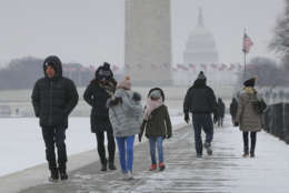 People are seen walking alongside the reflecting pool on the National Mall in Washington, Thursday, Jan. 4, 2018. Residents across a huge swath of the U.S. have awakened to the beginnings of a massive winter storm expected to deliver snow, ice and high winds followed by possible record-breaking cold as it moves up the Eastern Seaboard from the Carolinas to Maine. (AP Photo/Pablo Martinez Monsivais)