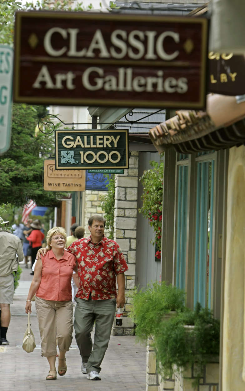 A couple walks past many of the numerous art galleries in Carmel-By-The-Sea, Calif., Tuesday July 12, 2005. Last fall the city council banned the opening of any more art galleries on an "urgency basis." The decision has drawn the ire of gallery owners, but residents are applauding, saying it might finally attract stores to town that sell socks and underwear.(AP Photo/Eric Risberg)