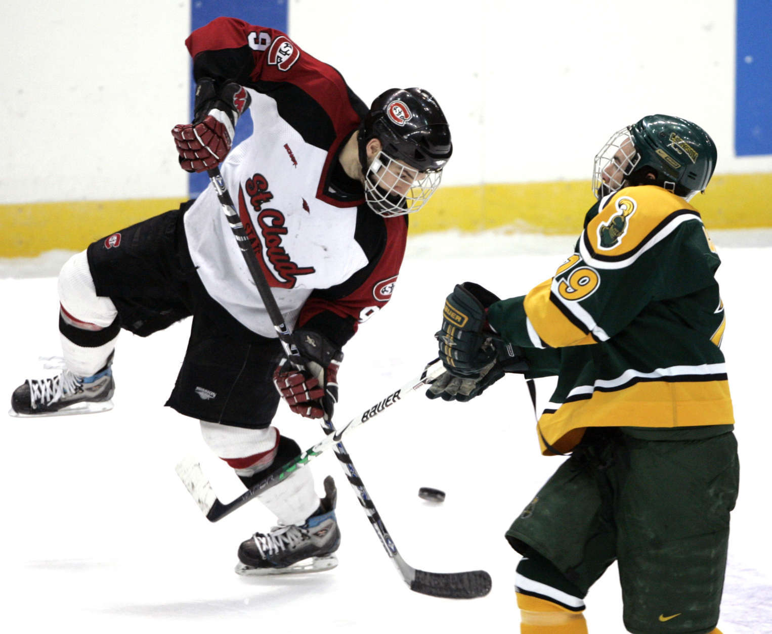 St. Cloud State center Garrett Roe (9) is checked by Clarkson winger David Cayer (19) during the second period of their NCAA East Regional semifinal hockey game in Albany, N.Y., Friday, March 28, 2008.  (AP Photo/Mike Groll)