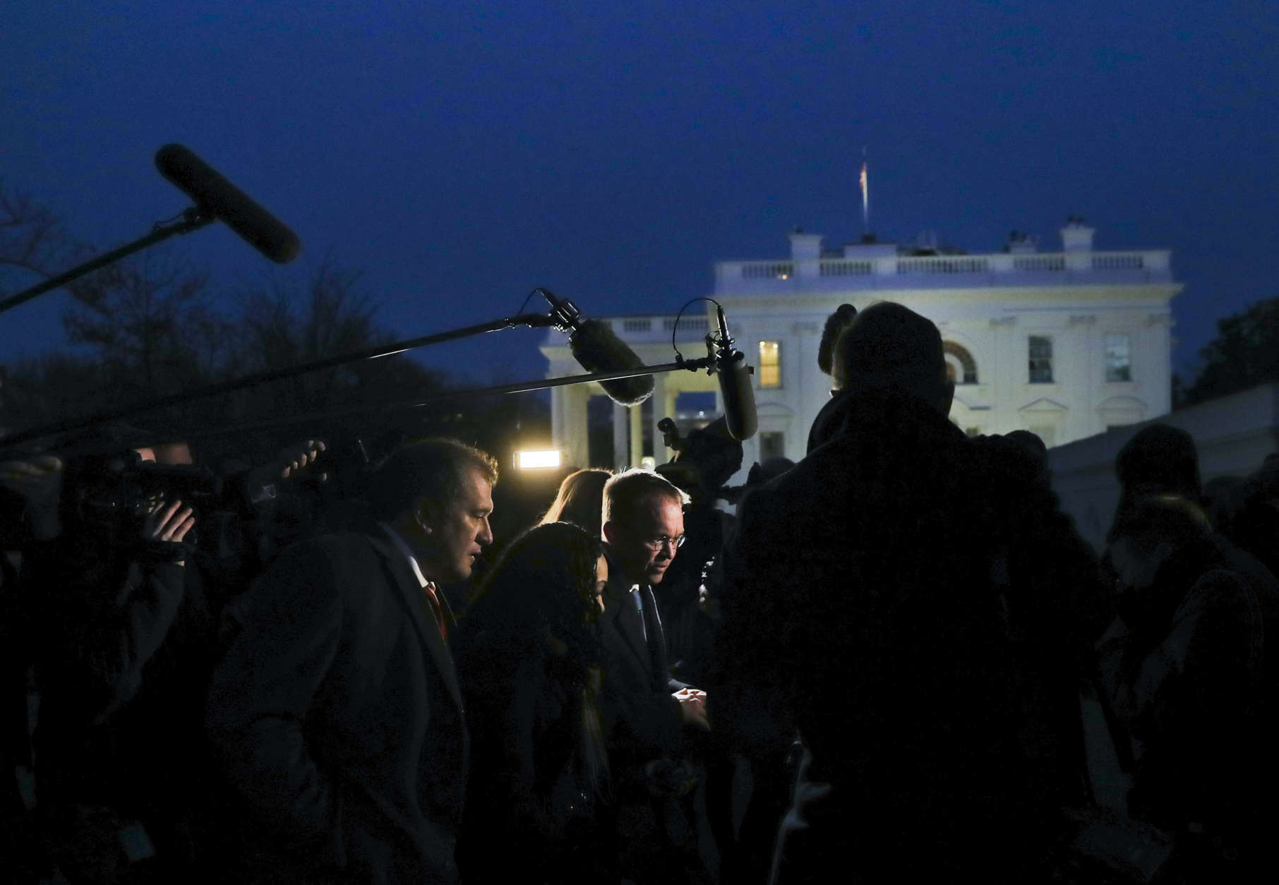 Director of the Office of Management and Budget Mick Mulvaney, center, is surrounded by members of the media outside the White House, Friday, Jan. 19, 2018, and is questioned about a potential government shutdown this weekend. (AP Photo/Pablo Martinez Monsivais)