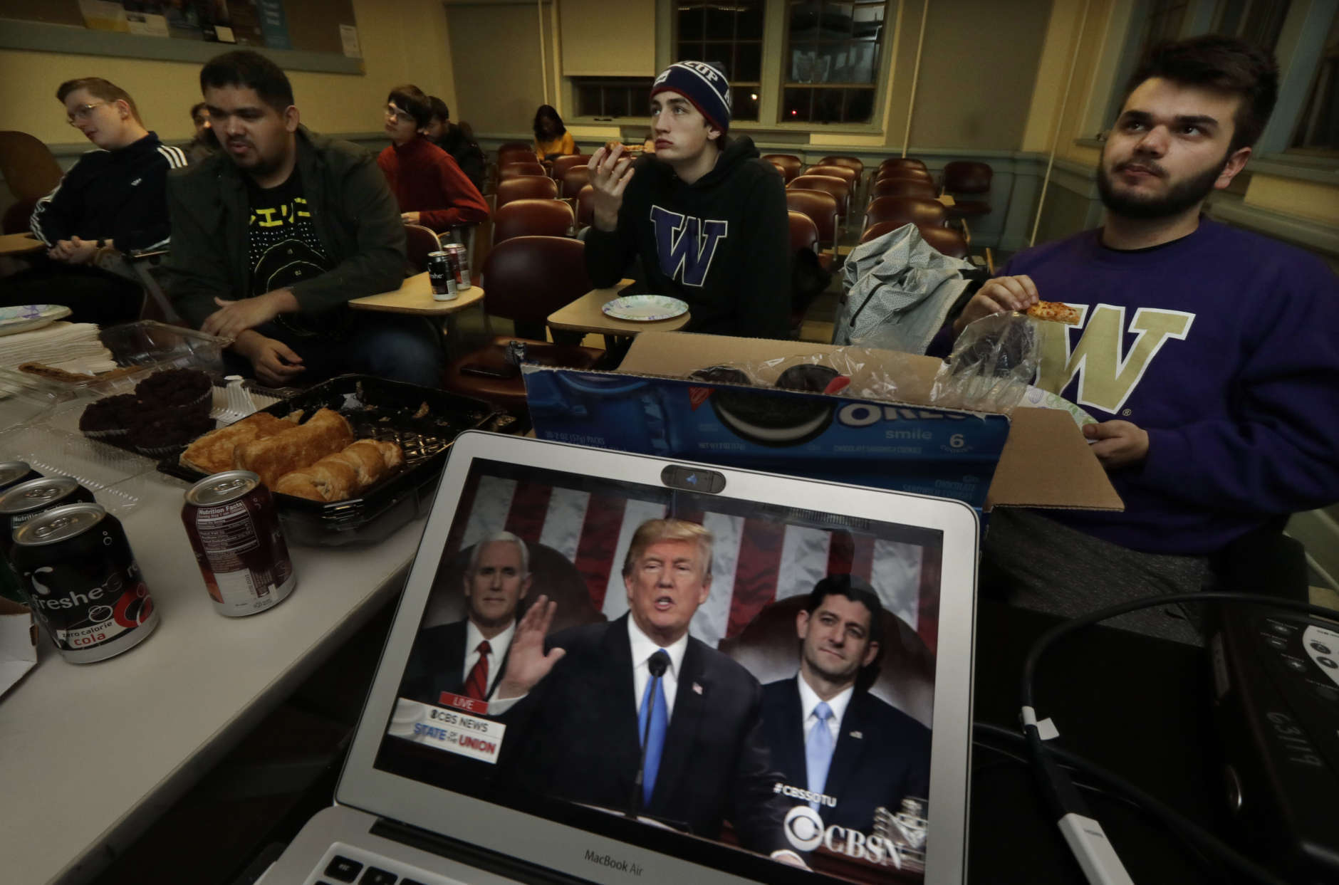 Members of the College Republicans at the University of Washington eat pizza and other snacks as they watch a broadcast of President Donald Trump as he gives his State of the Union speech during an on-campus viewing party, Tuesday, Jan. 30, 2018, in Seattle. (AP Photo/Ted S. Warren)