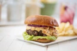 This May 2018 photo shows a burger with pimento cheese in New York. This dish is from a recipe by Katie Workman. (Cheyenne Cohen via AP)