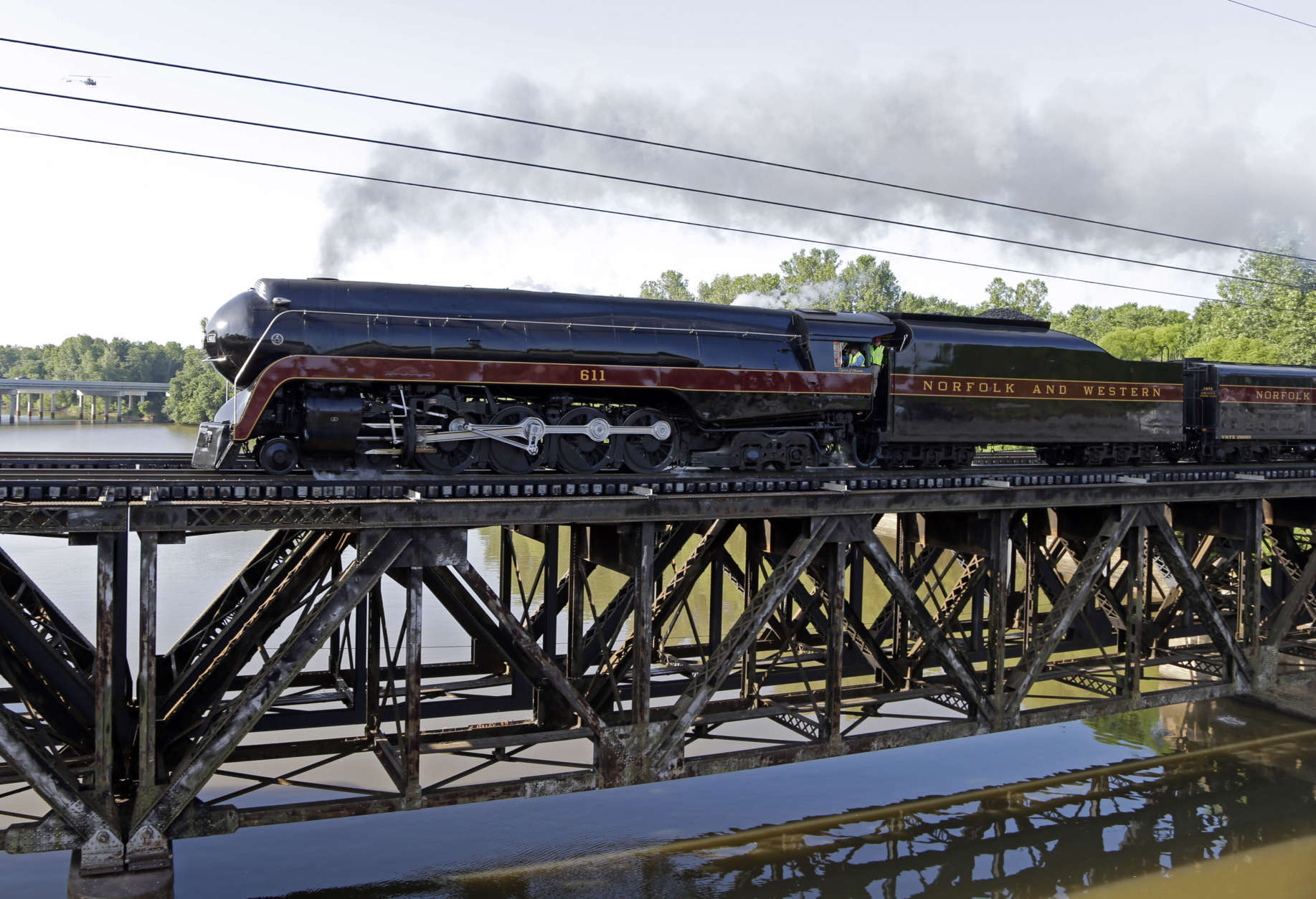 The Norfolk &amp; Western Class J No. 611 steam locomotive crosses a bridge over the Yadkin River after leaving the North Carolina Transportation Museum in Spencer, N.C., Saturday, May 30, 2015. The train, which has undergone a year-long restoration, is returning to the Virginia Museum of Transportation in Roanoke, Virginia. (AP Photo/Chuck Burton)
