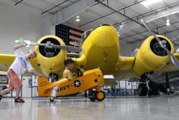 Two youngsters enjoy riding around in a toy plane as they ride in front of a Cessna T-50 "Bobcat" transport trainer plane, from 1939-1949, at the Commemorative Air Force Aviation Museum Thursday, Aug. 2, 2012, in Mesa, Ariz.(AP Photo/Ross D. Franklin)