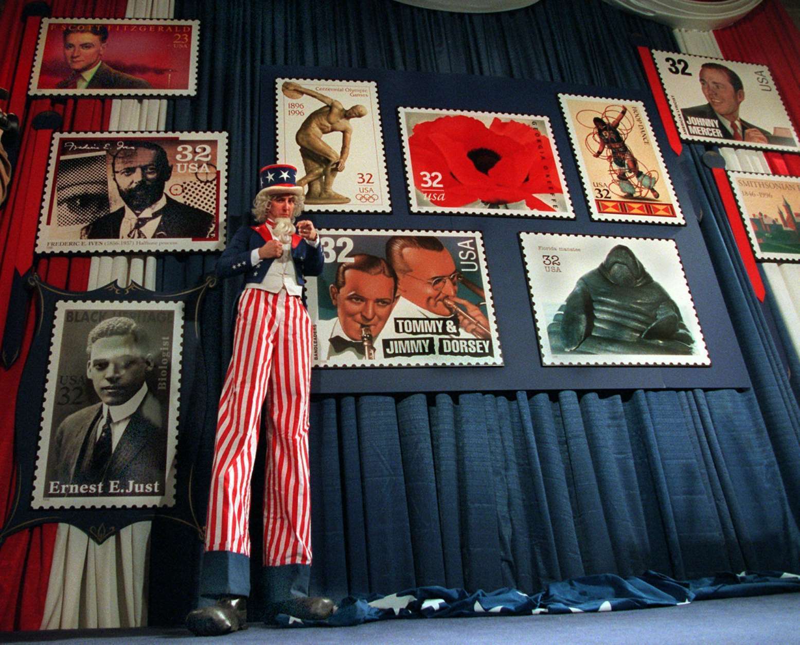 A stilted Uncle Sam, portrayed by Brian McNelis, stands in front of blow ups of proposed 1996 U.S. Postage Stamps during a news conference at the U.S. Postal Museum in Washington Tuesday Nov. 7, 1995 where the new designs were announced. (AP Photo/Charles Tasnadi)