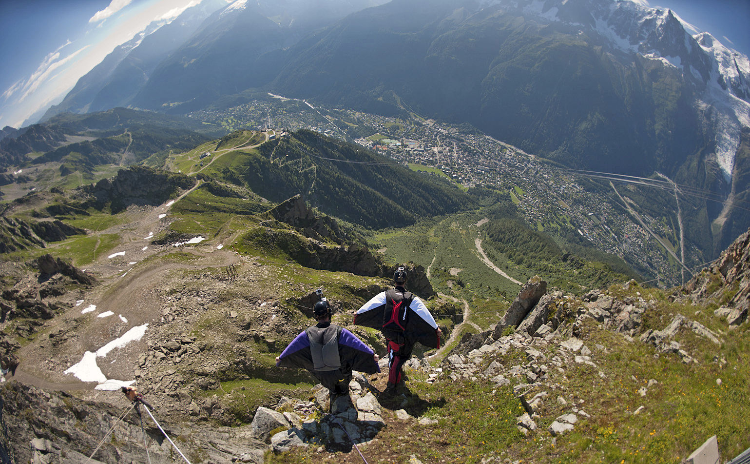 In this photo dated July 21, 2012, two base jumpers wearing wingsuits prepare to jump from the Brevent needle above Chamonix in the French Alps. For nearly two months, daredevils in skin-tight suits with batwing sleeves and a flap between their legs hurled themselves off the Brevent cliff, soaring through the Alpine skies. Last week, tragedy struck: A Norwegian wingsuit flyer was killed when his parachute failed to open. The next day, the mayor of Chamonix-Mont Blanc banned wingsuits. The decision has triggered a debate about how to weigh the dangers of extreme sport against the passion of the thrill-seekers the Alpine town has famously encouraged. (AP Photo/Cyril Duval)