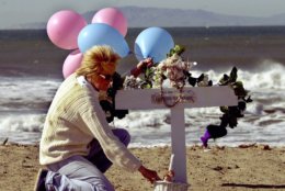 Nancy Fry of Oxnard Calif., arranges balloons and a basket at a  memorial on Silver Strand Beach in Oxnard, Calif., Tuesday, Jan. 30, 2001, created in memory of the 88 victims of the Jan. 31, 2000 crash of Alaska Airlines Flight 261.  The twin-engine MD-83 was on its way to San Francisco and then Seattle when it started pitching, then spiraled from nearly 18,000 feet into the Pacific Ocean.  (AP Photo/Nick Ut)