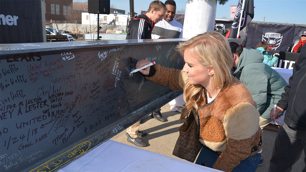 D.C. United fans on Friday sign the topping-off beam at the Audi Field construction site. (Juan Herrera/Capital News Service)