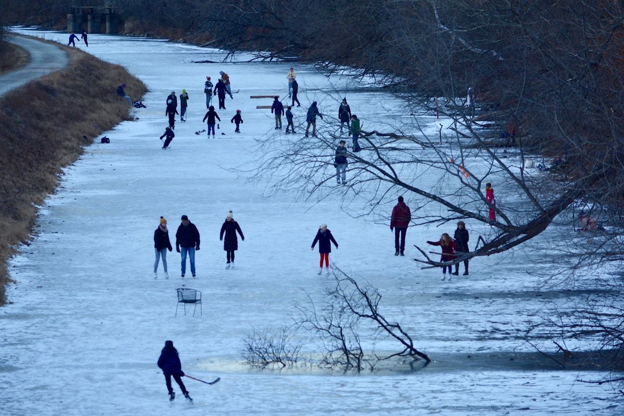 Droves of people young and old carve into the frozen surface of the C&O Canal on Tuesday, January 2, 2018. For many families, ice skating in the National Park is a tradition that goes back generations.
 (WTOP/Dave Dildine)