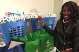 Dyesha Harris, 23, shows off the gift card and home supplies she received at the Home For The Holidays lease signing ceremony. (WTOP/Kristi King)