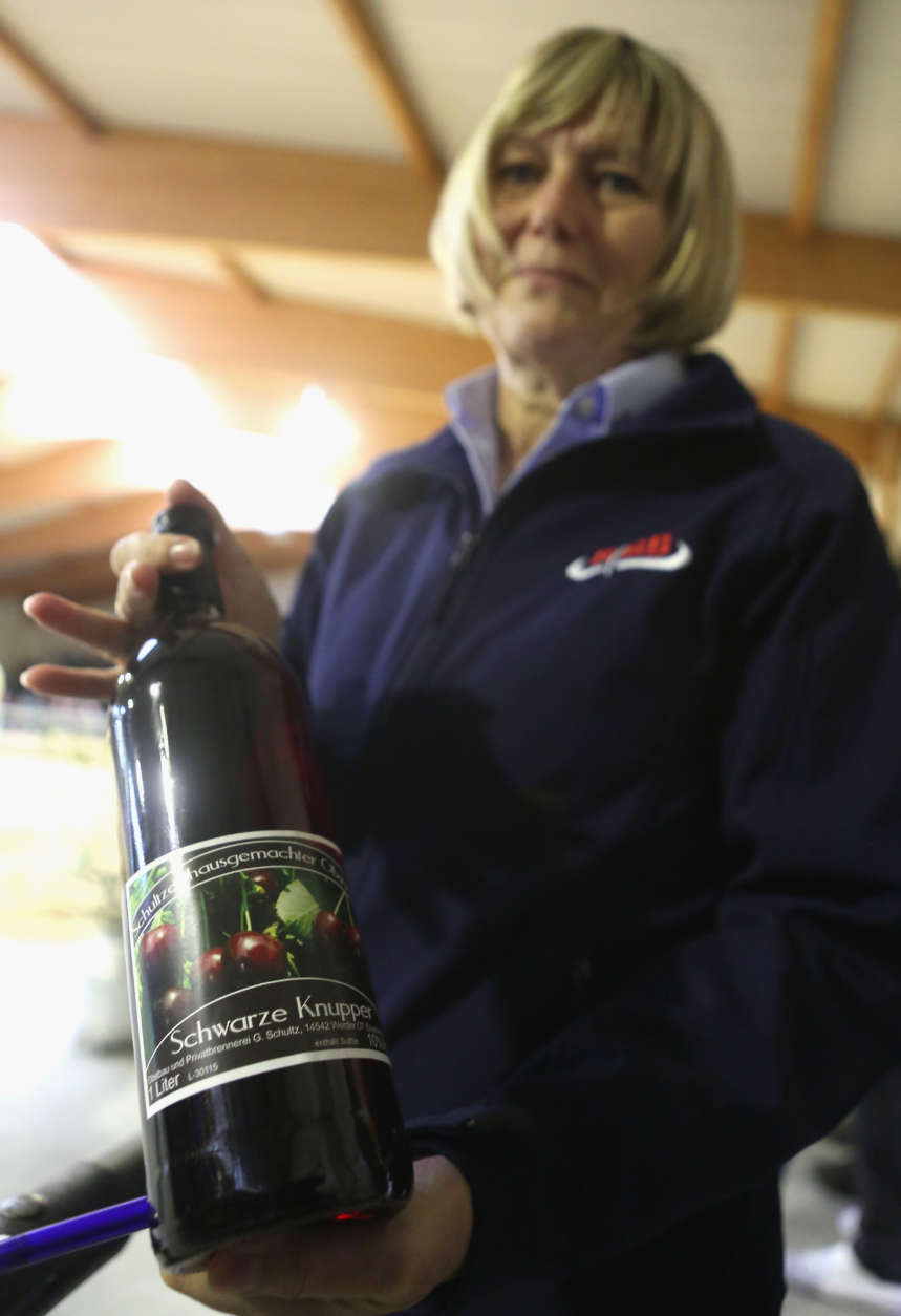 GROSS KREUTZ, GERMANY - APRIL 11:  An official shows a bottle of local cherry wine provided to farmers agreeing to purchase a heifer for at least 2500 euros, the minimum amount required to receive the congratulatory gift, during an annual heifer auction on April 11, 2017 in Gross Kreutz, Germany. Around 80 Angus, Charolais, Hereford, Uckermärker, Blonde d'Aquitaine, Fleckvieh, Limousin, and Galloway cattle are presented for purchase at the event.  (Photo by Adam Berry/Getty Images)