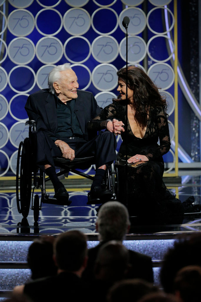 BEVERLY HILLS, CA - JANUARY 07:  In this handout photo provided by NBCUniversal, Presenters Kirk Douglas and Catherine Zeta Jones speak onstage during the 75th Annual Golden Globe Awards at The Beverly Hilton Hotel on January 7, 2018 in Beverly Hills, California.  (Photo by Paul Drinkwater/NBCUniversal via Getty Images)