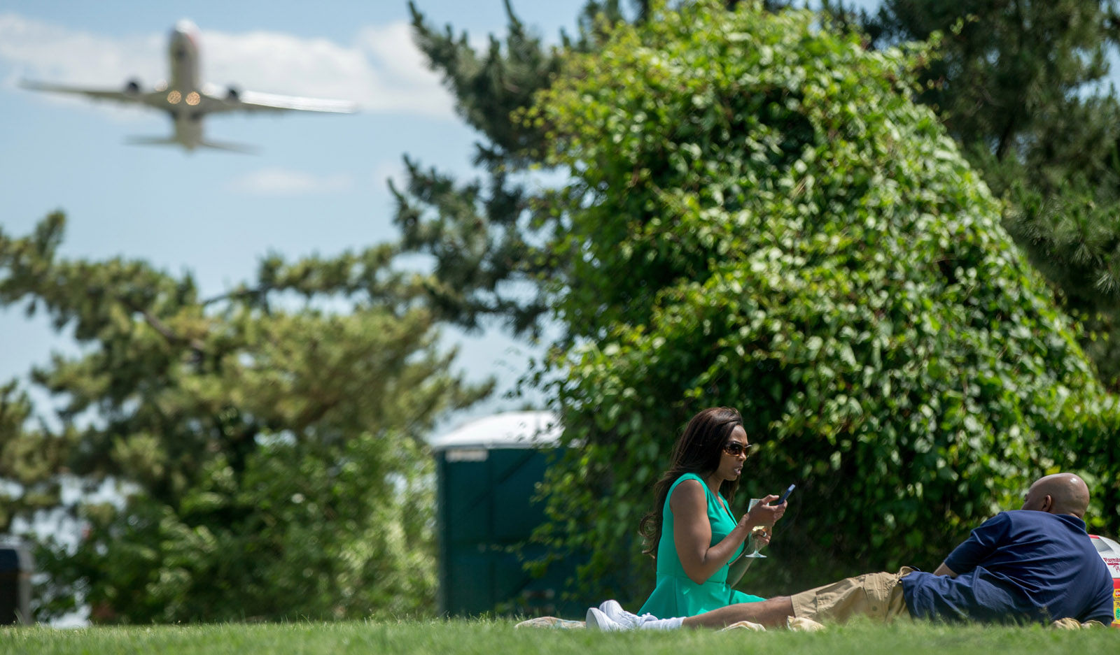 A plane takes off from Washington's Ronald Reagan National Airport as Marcel Clark of Washington, right, and Rosemary Loza of Rockville, Md. picnic at Gravelly Point Park in Arlington, Va., Wednesday, June 8, 2016. (AP Photo/Andrew Harnik)