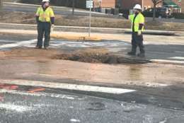 Utility crews work on a broken water main in Fairfax. (WTOP/Michael O'Connell)