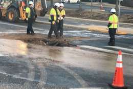 Utility crews work on repairing a broken water main Wednesday morning in Fairfax County. (WTOP/Michael O'Connell)