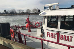 D.C. firefighters, specially trained by the U.S. Coast Guard, work to break up large ice sheets that formed in frigid temperatures blocking access on the waterway in an emergency.
 (WTOP/Megan Cloherty)