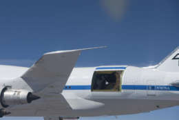 With its primary mirror covered by a protective sun shade, the German-built infrared telescope nestled in its cavity in the rear fuselage of NASA's SOFIA flying observatory is easily visible in this close-up image taken during a test flight. The small blue lines surrounding the telescope cavity are aerodynamic tufts to visibly show how air flows over the cavity in different flight attitudes. (Courtesy NASA/USRA)
