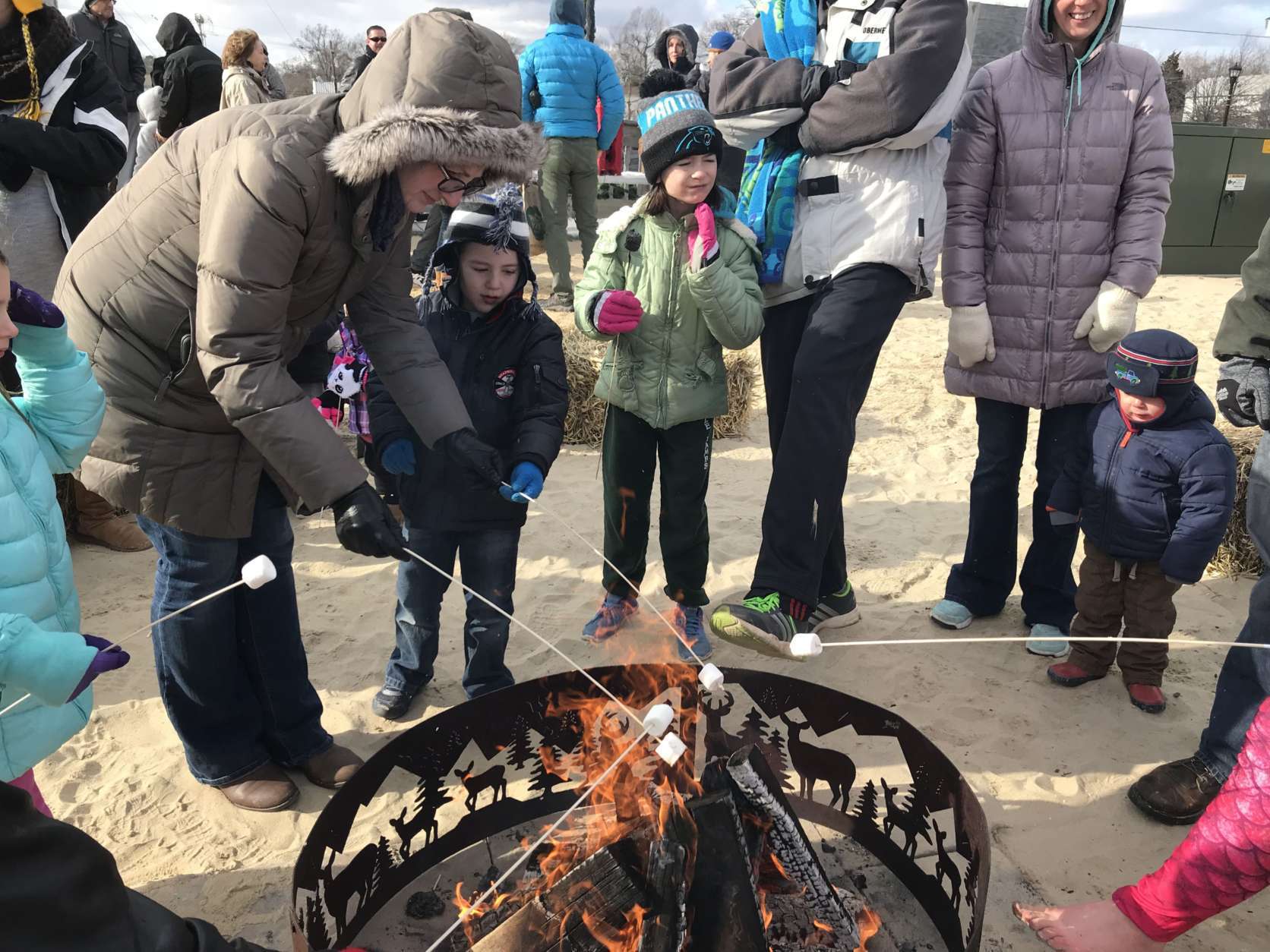 After the plunge, some people gathered to toast marshmallows and warm up at a fire pit on the beach. (WTOP/Michelle Basch)