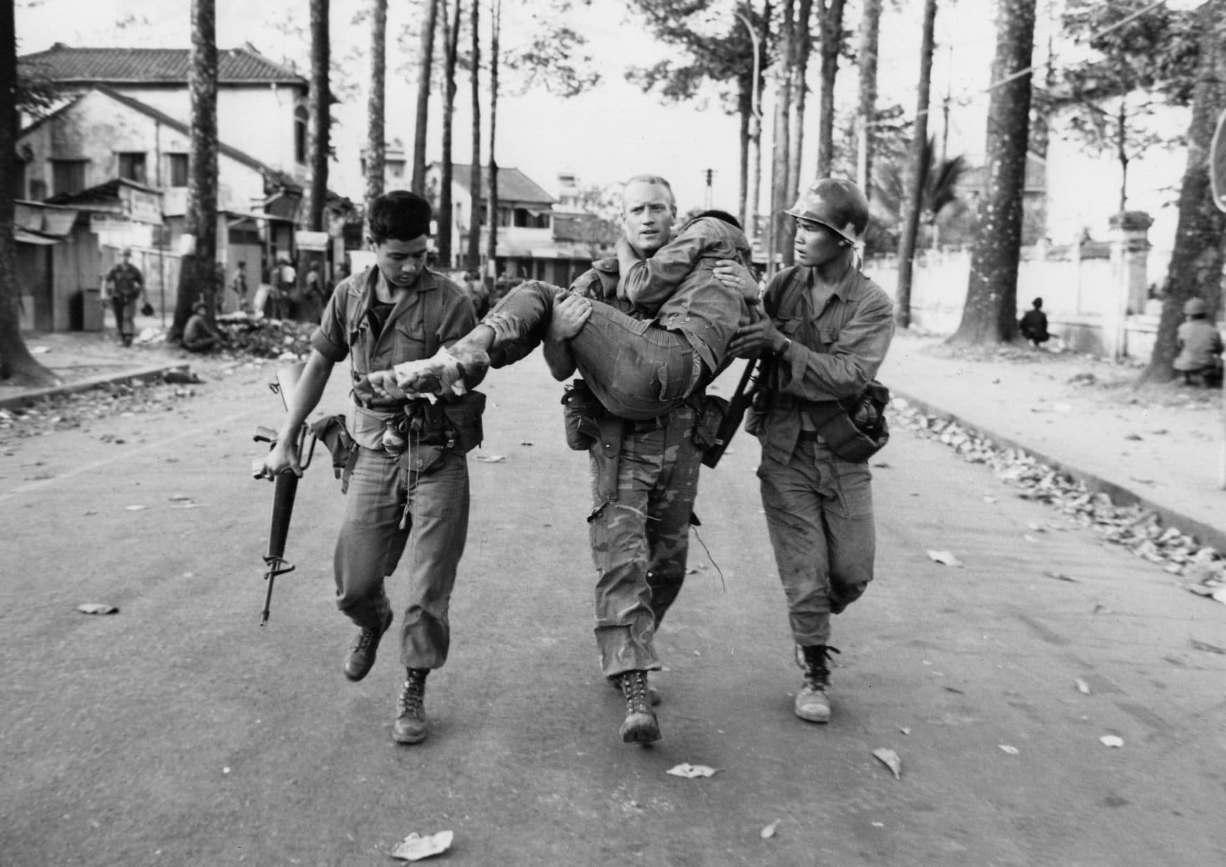 FILE - In his Feb. 6, 1968, file photo, First Lt. Gary D. Jackson of Dayton, Ohio, carries a wounded South Vietnamese Ranger to an ambulance after a brief but intense battle with the Viet Cong during the Tet Offensive near the National Sports Stadium in the Cholon section of Saigon. Early on the morning of Jan. 31, 1968, as Vietnamese celebrated the Lunar New Year, or Tet as it is known locally, Communist forces launched a wave of coordinated surprise attacks across South Vietnam. The campaign, one of the largest of the Vietnam War, led to intense fighting and heavy casualties in cities and towns across the South. (AP Photo/Dang Van Phuoc, File)