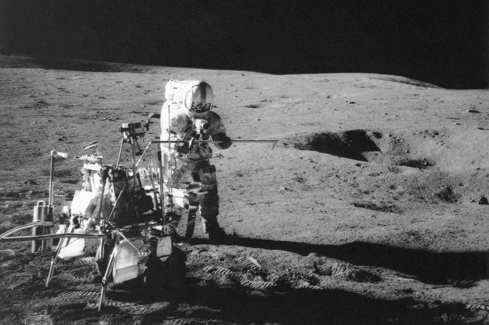 FILE - In this Feb. 13, 1971 file photo, Apollo 14 astronaut Alan B. Shepard Jr. conducts an experiment near a lunar crater, using an instrument from a two-wheeled cart carrying various tools. On Wednesday, Jan. 11, 2017, a California-led research team reported that the moon formed within 60 million years of the birth of the solar system. Previous estimates ranged within 100 million years, all the way out to 200 million years of the solar system’s creation. (NASA via AP)