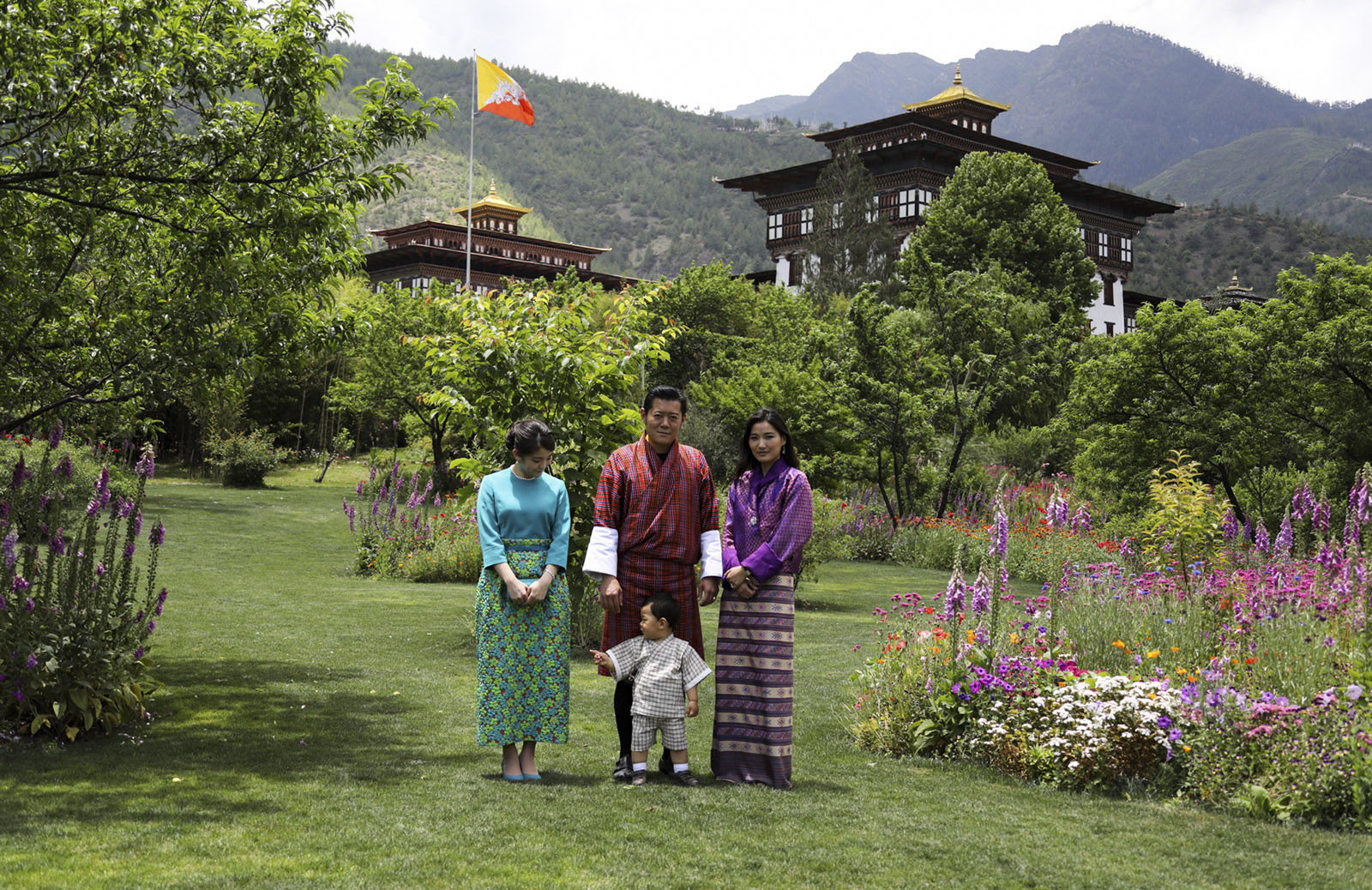 In this handout photograph released by Royal Office for Media Bhutan, Japan's Princess Mako, left, the granddaughter of Emperor Akihito, watches Jigme Namgyel Wangchuck son of Bhutan's King Jigme Khesar Namgyal Wangchuck, center, and Queen Jetsun Pema, right, as they pose for a photograph in Thimphu, Bhutan on Friday, June 2, 2017. (Royal Office for Media Bhutan via AP)