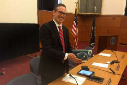 Virginia Board of Elections chairman James Alcorn shows off the blue stoneware blue used in the drawing to break a tie in the disputed 94th District House Race on Jan. 4, 2018, in Richmond, Virginia. Virginia artist Steven Glass crafted the vessel, which represents the sky on the outside of the bowl and the oxide red inside represents the earth. (WTOP/Max Smith)