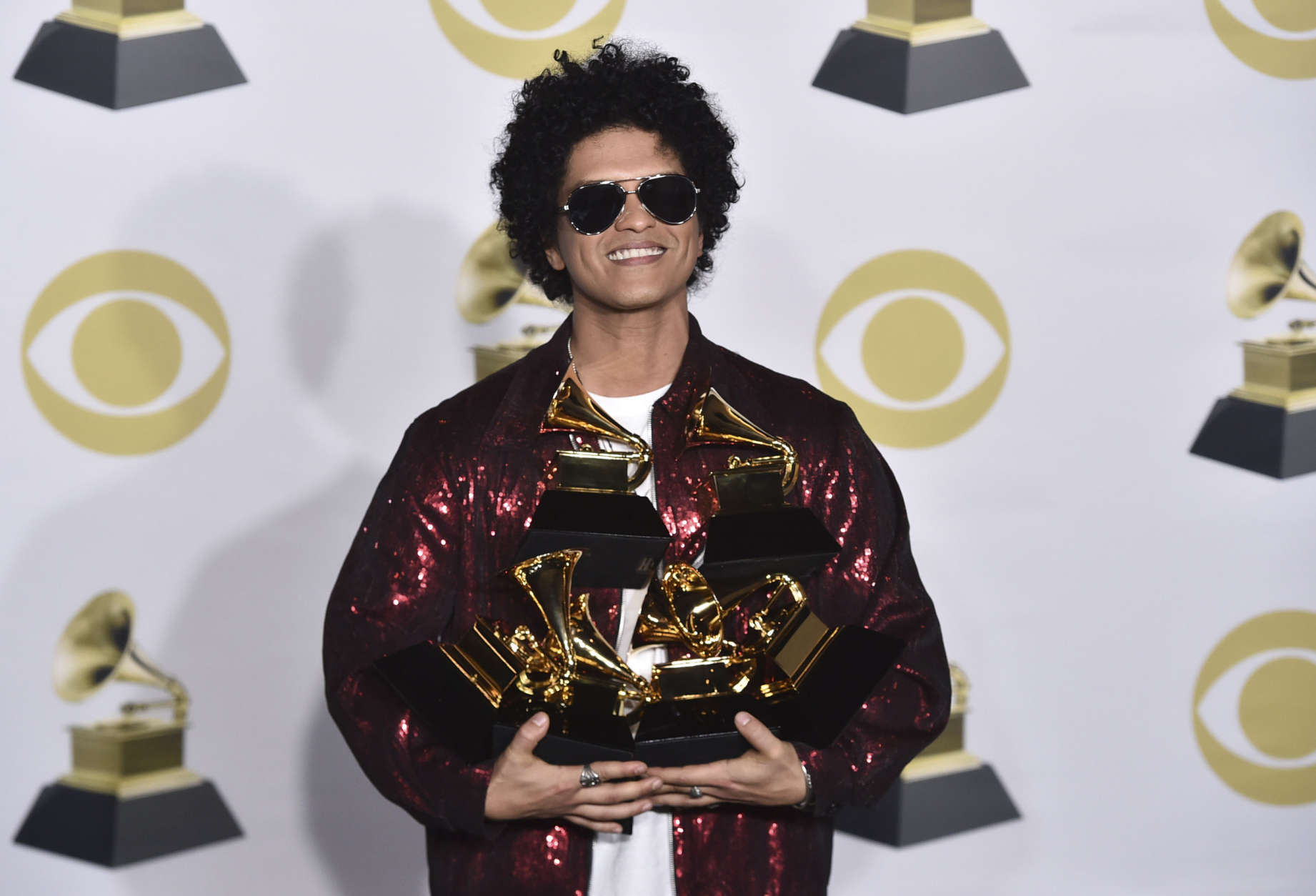 Bruno Mars poses in the press room with his awards for best R&amp;B album, record of the year, album of the year, best engineered album, non-classical, for "24K Magic," and song of the year, best R&amp;B performance and best R&amp;B song, for "That's What I Like" at the 60th annual Grammy Awards at Madison Square Garden on Sunday, Jan. 28, 2018, in New York. (Photo by Charles Sykes/Invision/AP)
