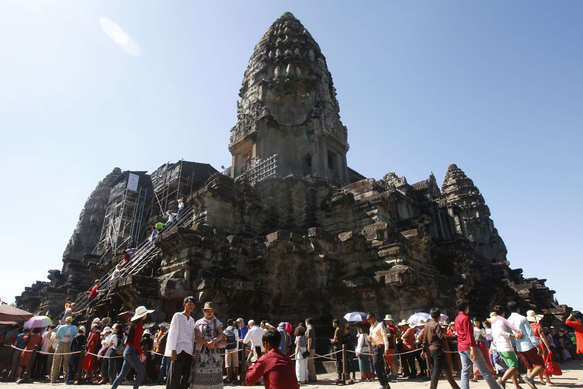 In this Sunday, Dec. 31, 2017, photo, tourists line up for stepping up Angkor Wat temple outside Siem Reap, Cambodia. Tourists celebrated New Year at Angkor Wat temple where is Cambodia's main tourist destination. The temples, built between the 9th and 15th centuries. (AP Photo/Heng Sinith)