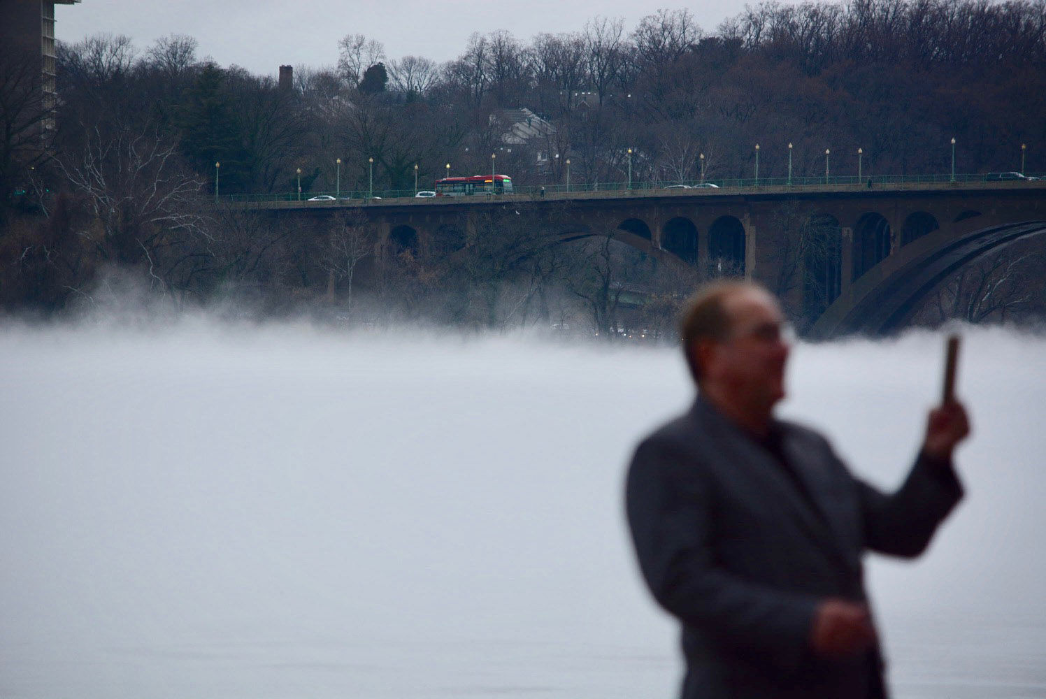 Dense fog rises off the Potomac River as a man takes a selfie near the Key Bridge on Friday, Jan. 12, 2018. (WTOP/Dave Dildine)