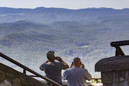 In this Sept. 15, 2016, photo, visitors take pictures of the Great Smoky Mountains National Park from a lookout point on the Foothills Parkway near Chilhowee, Tenn. Work is underway to complete the extension of scenic route running near the northern boundary of the park. (AP Photo/Erik Schelzig)