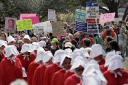 Members of the "Texas Handmaids" lead a women's march to the Texas State Capitol on the one-year anniversary of President Donald Trump's inauguration, Saturday, Jan. 20, 2018, in Austin, Texas. (AP Photo/Eric Gay)
