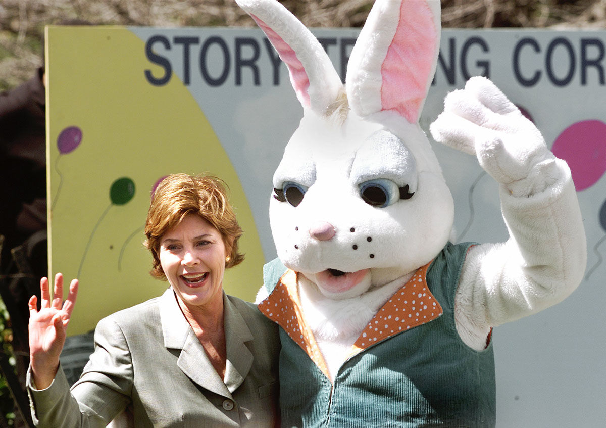 First lady Laura Bush waves with the Easter Bunny at the annual White House Easter Egg Roll, Monday, April 1, 2002, in Washington.  10,800 eggs were boiled, the president's dog was captured in a chocolate sculpture and the White House opened the gates to hundreds of children for the annual egg roll on the South Lawn.     (AP Photo/Ron Edmonds)