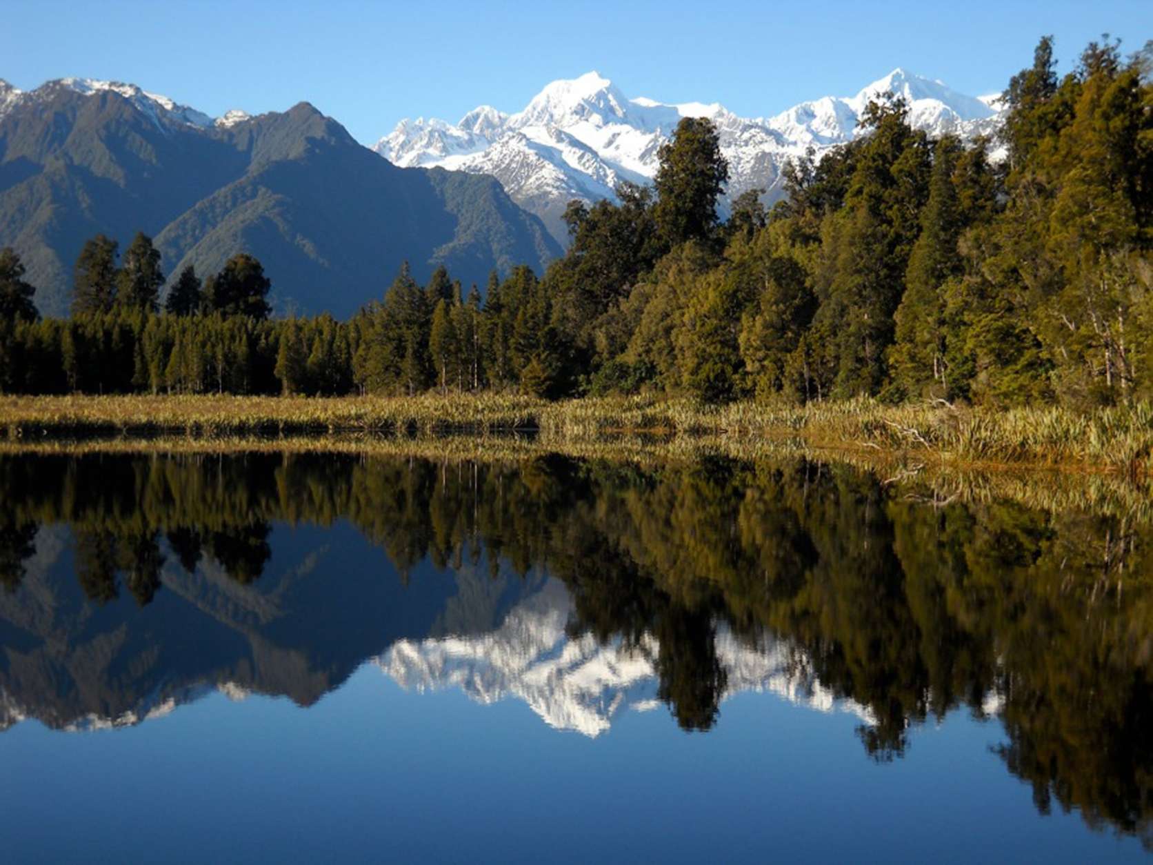 This photo taken June 1, 2009 shows the snow-capped Aoraki, also known as Mount Cook, is reflected in the still waters of Lake Matheson, New Zealand.  Aoraki, part of the Southern Alps, is the highest peak in the Southern Hemisphere. (AP Photo/Kathy Matheson)