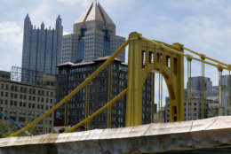 The tops to the PPG Tower spires, left, and the Fifth Avenue Place rise above the Andy Warhol Bridge in the Pittsburgh skyline, Wednesday, July 26, 2017. (AP Photo/Keith Srakocic)