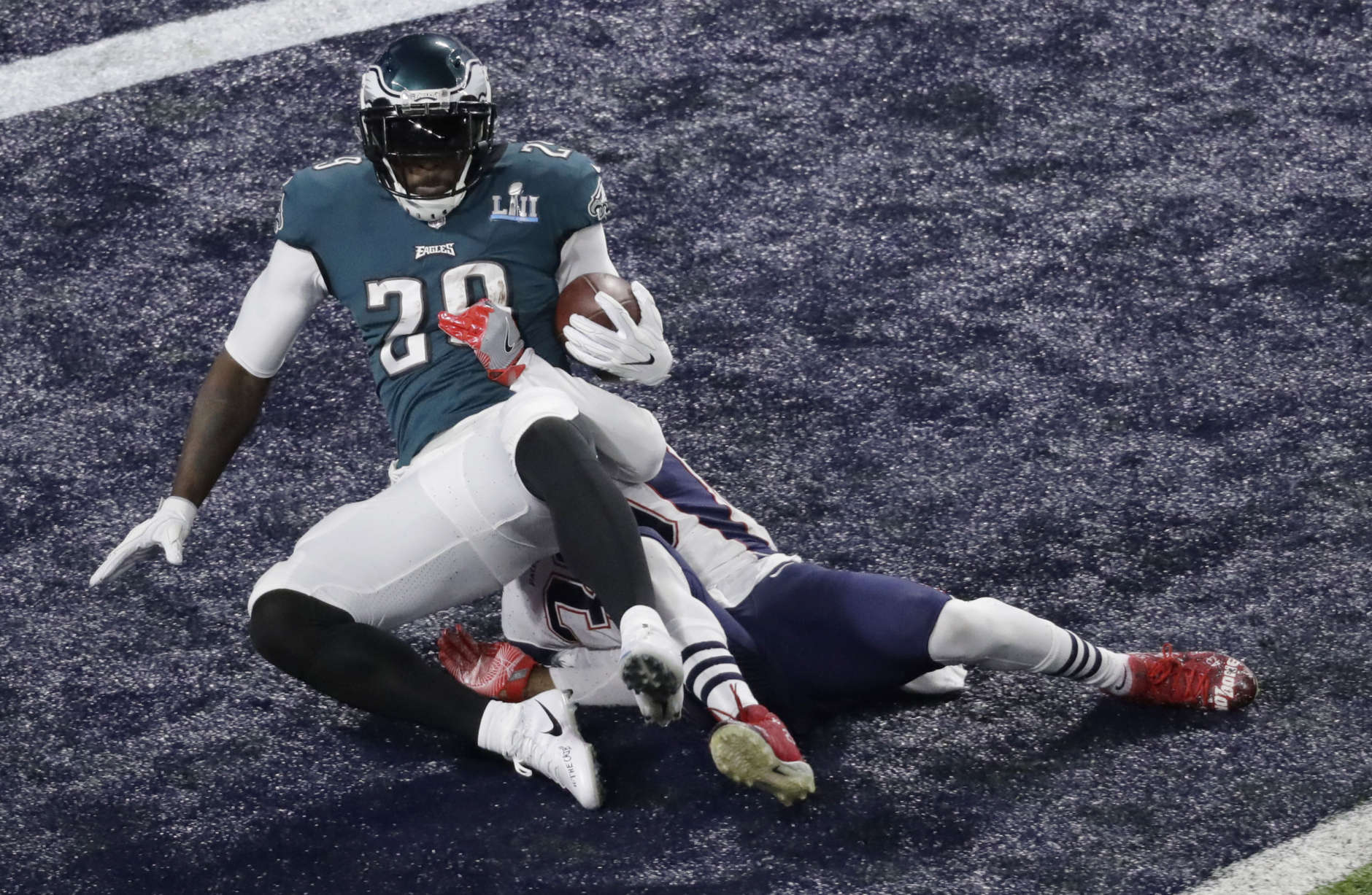 Philadelphia Eagles running back LeGarrette Blount, left, scores past New England Patriots strong safety Duron Harmon during the first half of the NFL Super Bowl 52 football game Sunday, Feb. 4, 2018, in Minneapolis.(AP Photo/Eric Gay)