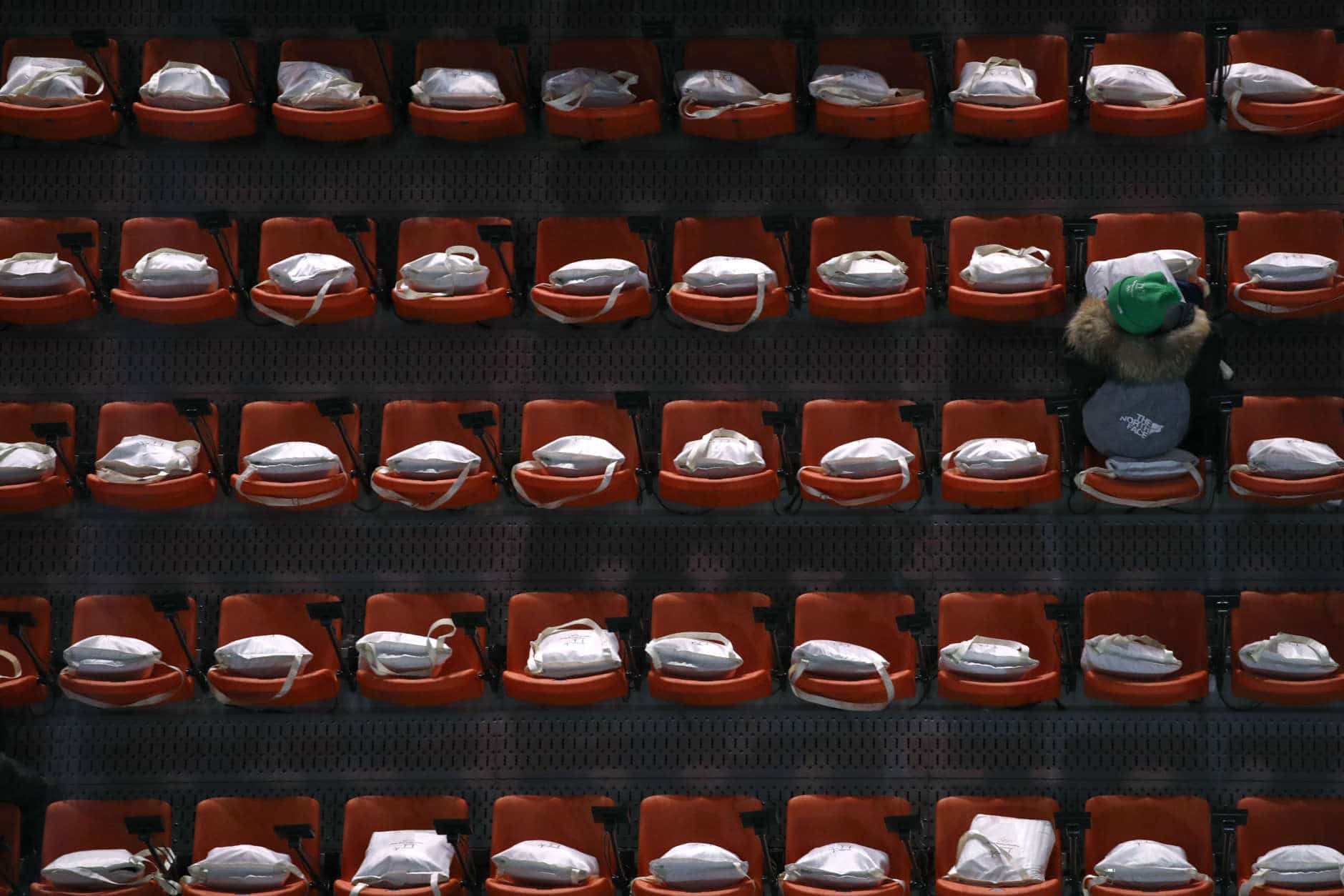 A spectator waits for the closing ceremony of the 2018 Winter Olympics to begin in Pyeongchang, South Korea, Sunday, Feb. 25, 2018. (AP Photo/Charlie Riedel)