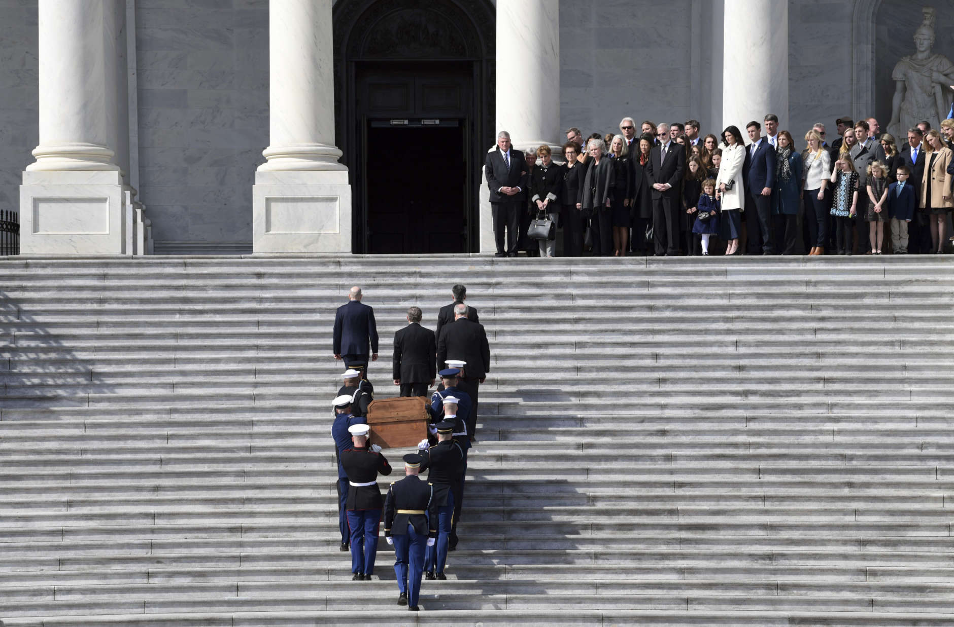 The family of Rev. Billy Graham watches as the casket of Rev. Billy Graham is carried up the steps of the U.S. Capitol in Washington, Wednesday, Feb. 28, 2018, where it will lie in honor in the Rotunda. It's a rare honor for a private citizen to lie in honor at the Capitol. Graham died Wednesday in his sleep at his North Carolina home. He was 99. (AP Photo/Susan Walsh, Pool)