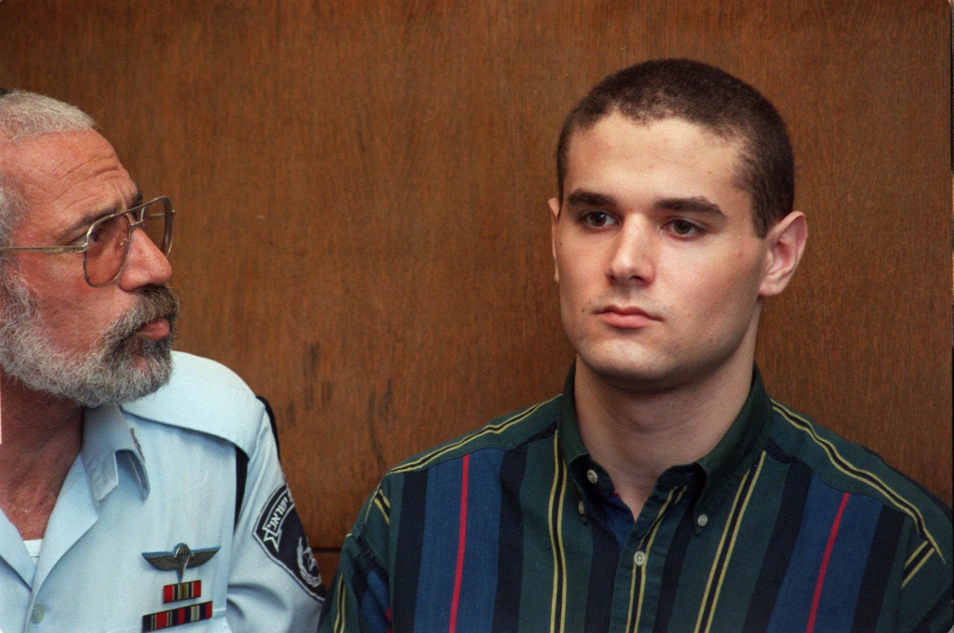 An Israeli police officer looks at Samuel Sheinbein at the Tel Aviv court Thursday, Sept. 2, 1999.  The Maryland teen-ager admitted in an Israeli court Thursday that he strangled an acquaintance in 1997, part of a plea bargain under which he will serve 24 years in an Israeli prison.   (AP Photo/Eyal Warshavsky)