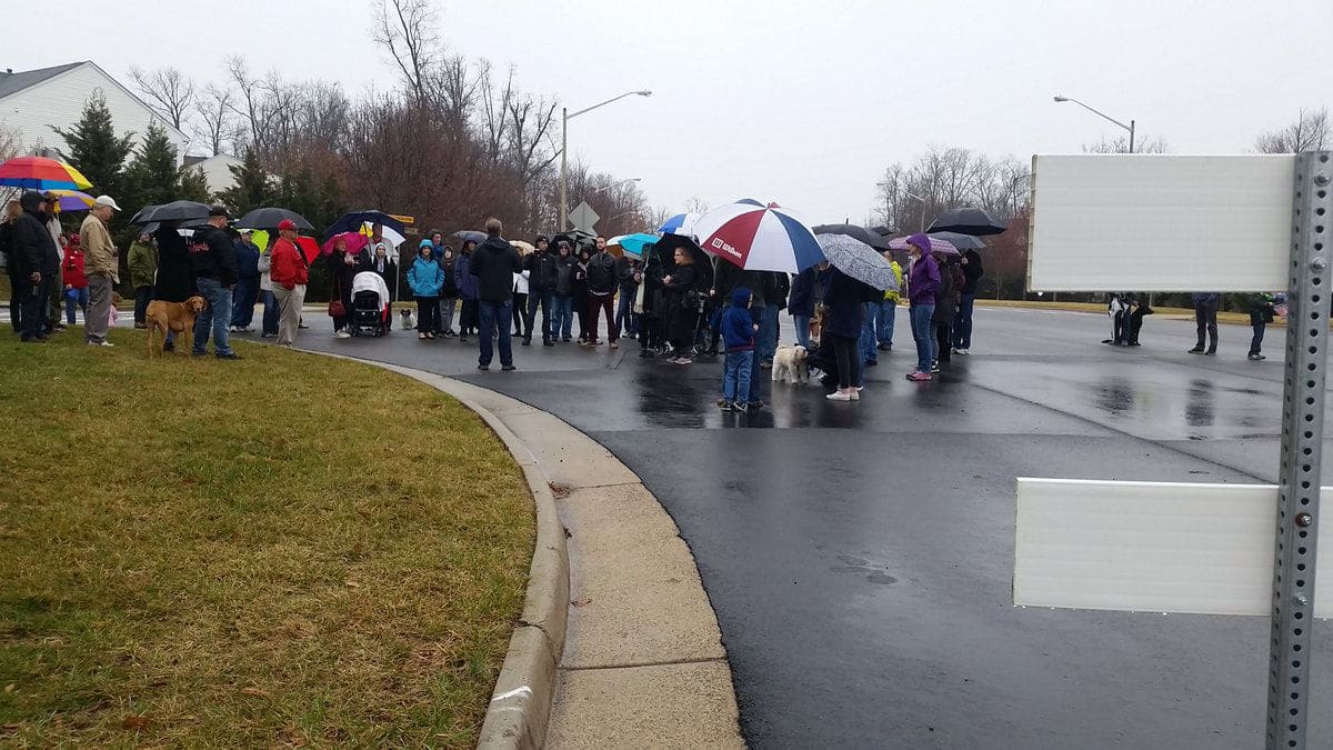Neighbors of Kincaid Forest a neighborhood in Leesburg that backs up to the land where DC United’s training facility and minor league stadium would go, came out in the pouring rain Saturday to rally against Kincaid Blvd opening to stadium traffic. (WTOP/Kathy Stewart)
