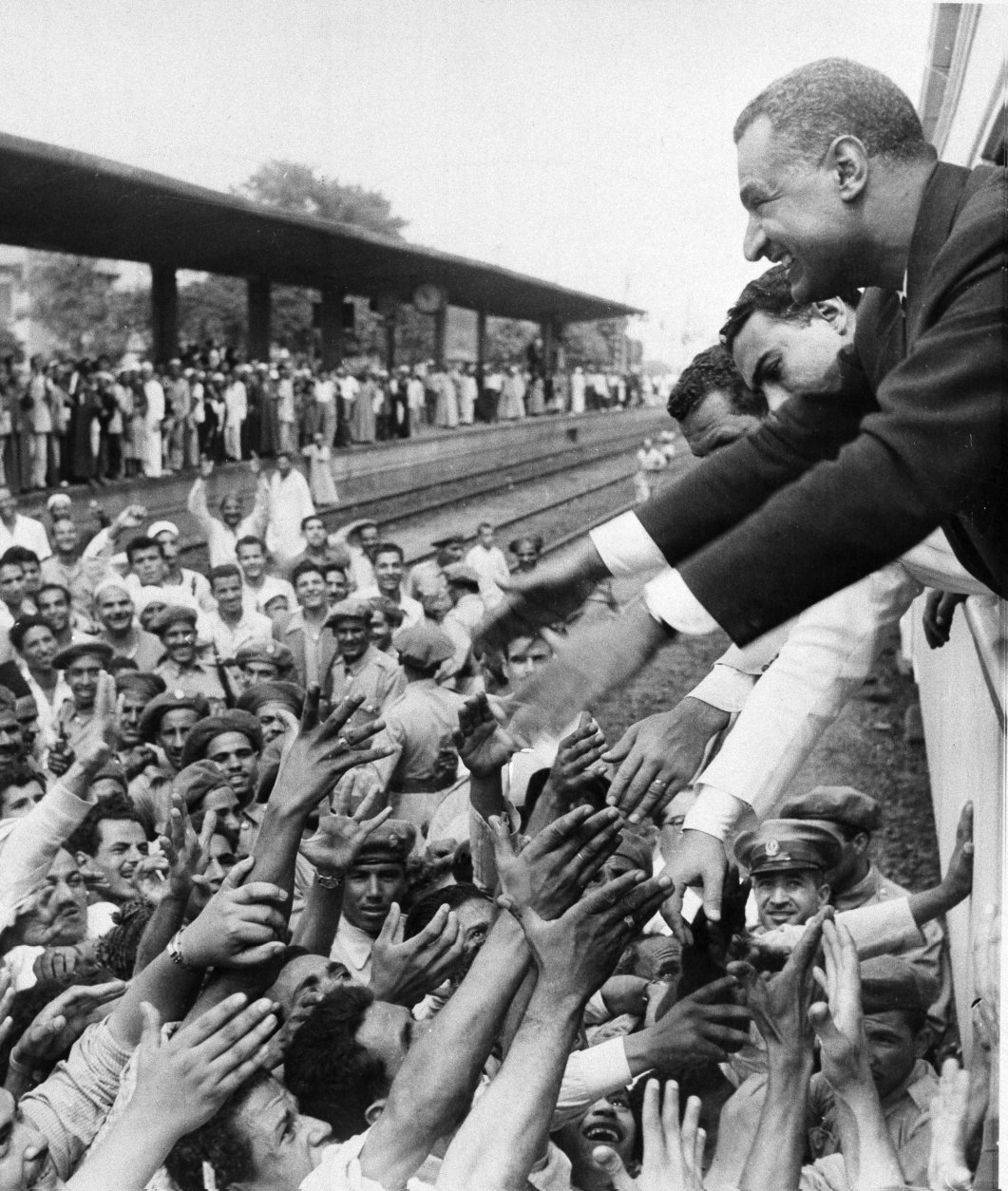 Egypt's President Gamal Abdel Nasser stretches his arms to greet fellow Egyptians during a stop at one of the stations en route from Alexandria to Cairo, July 28, 1956. Earlier Nasser shouted an angry reply to British and French protests against his nationalization of the all-important Suez Canal. he was welcomed by cheering crowds which greeted him on his return to the capital, where he announced the taking-over of the canal the night of July 27.  (AP Photo)